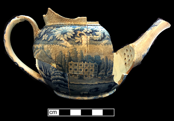 Pearlware teapot printed underglaze in medium blue.  Scene shows a shepherd and sheep in a country estate setting.   Continuous repeating floral border.  Transferware Collector’s Club named this pattern “Elegant Shepherd Boy”. 3.5” base diameter.